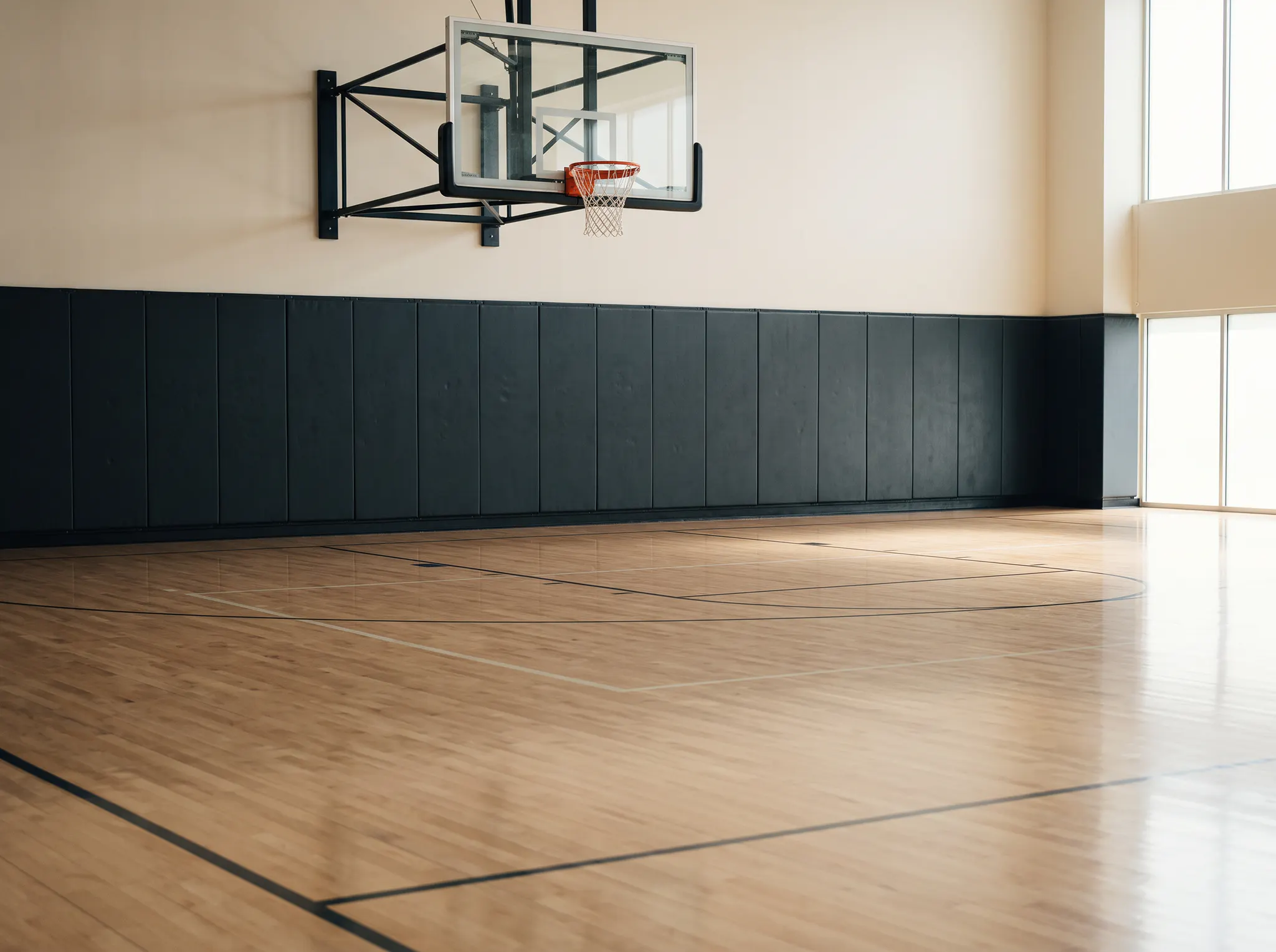 An empty indoor basketball court and hoop